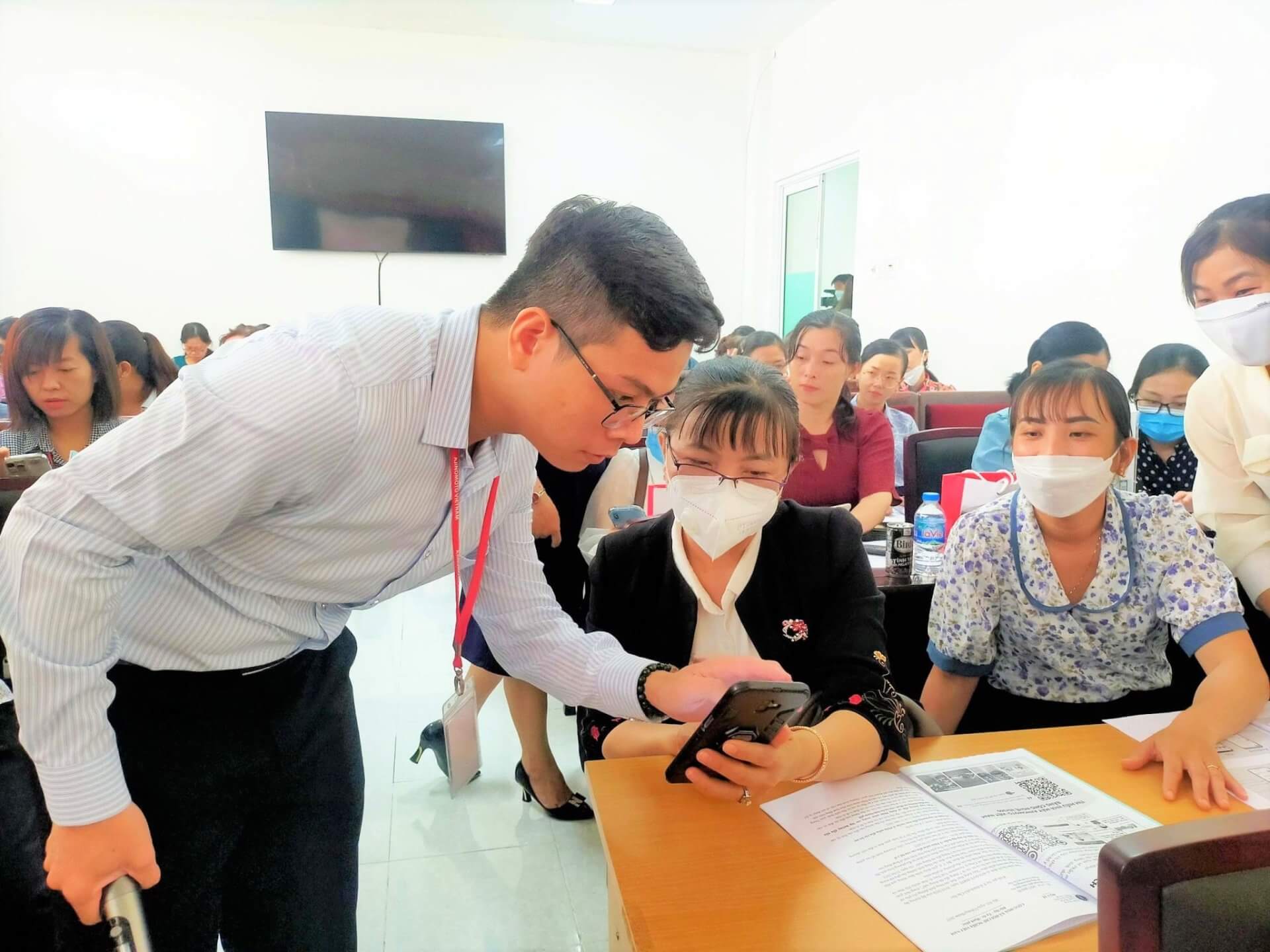 O supervisor Le Tan Hoa, do Departamento AVN's_PR, mostra aos funcionários da saúde como usar a plataforma digital MCP