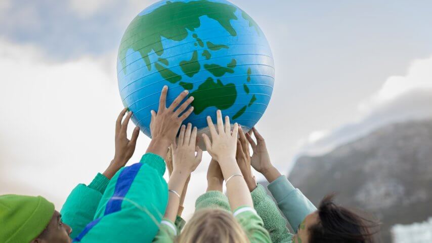 Group of teenagers holding up the world