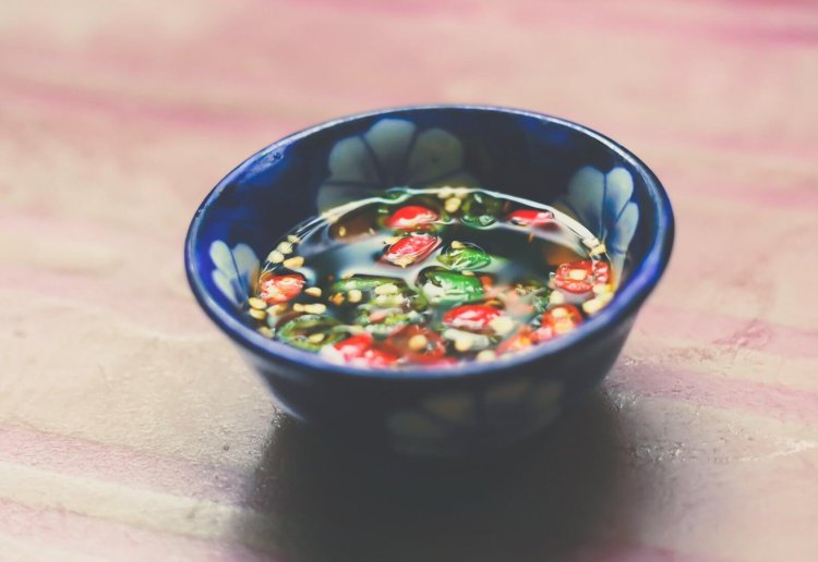 Nuoc Mam - sauce de poisson épicée vietnamienne dans un petit bol sur fond de bois