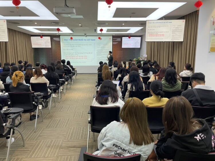 학생들을 위한 시설 견학 중 감칠맛을 활용한 맛있는 소금 감소에 대한 정보를 공유하는 AVN 직원